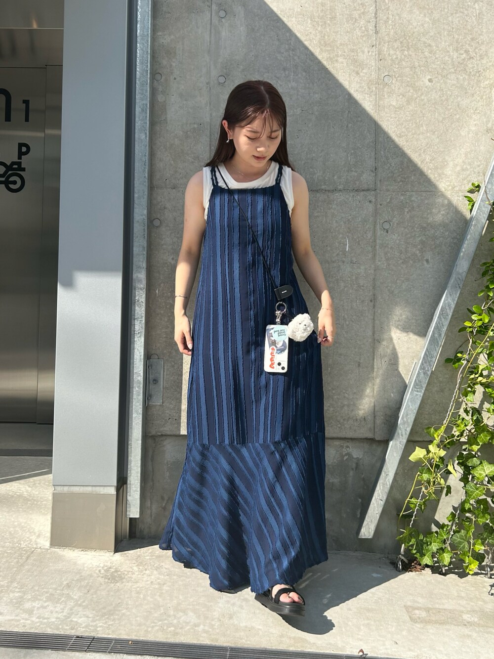 ブルー系のワンピース、ブラック系のスマホグッズ、ホワイト系のスマホグッズを着用したレディースの夏コーディネートの2枚目の写真