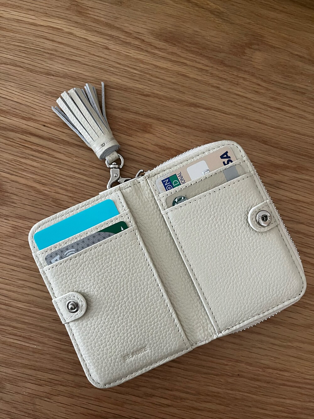 ホワイト系の財布を着用したレディースの秋コーディネートの2枚目の写真