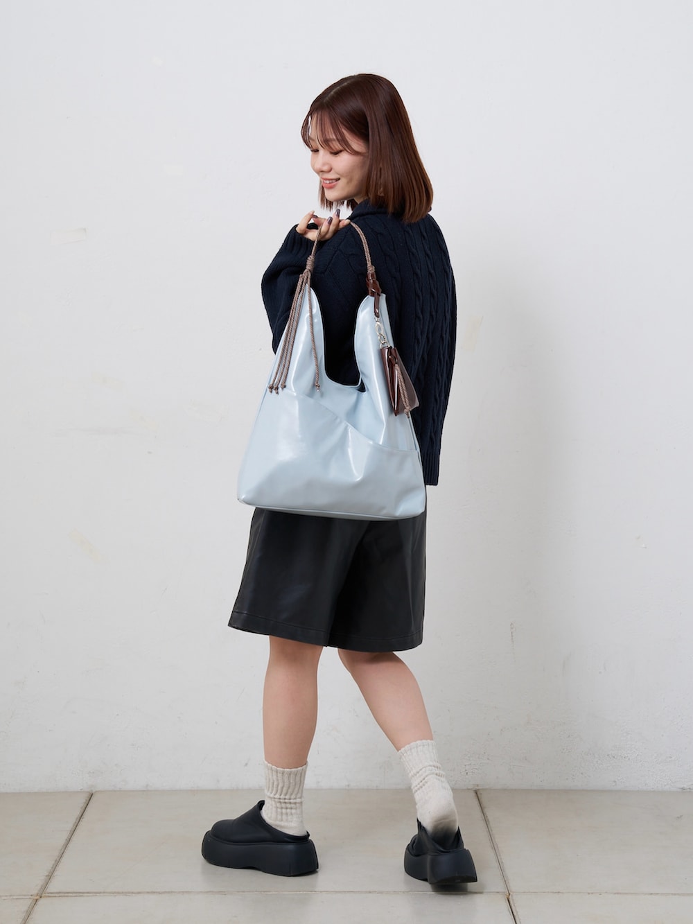 ブルー系のトートバッグを着用したレディースの春コーディネートの2枚目の写真