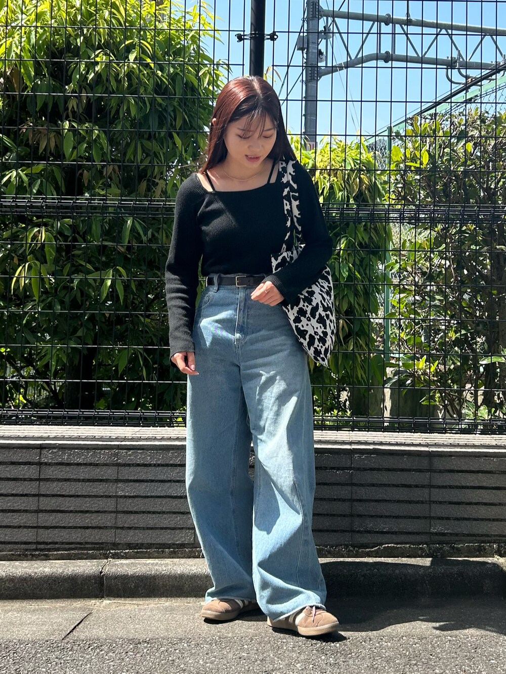 ホワイト系のトートバッグ、ブラック系のニット/セーター、ブルー系のデニムパンツを着用したレディースの春コーディネートの2枚目の写真