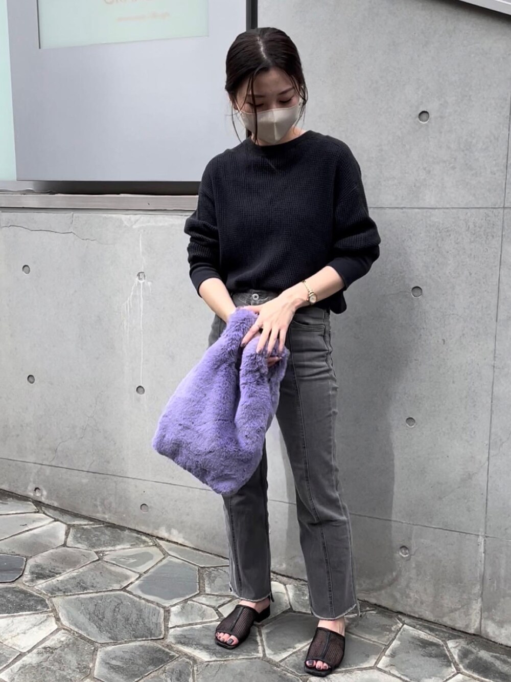 パープル系のハンドバッグ、ブラック系のTシャツ/カットソー、ブラック系のデニムパンツを着用したレディースの秋コーディネートの2枚目の写真