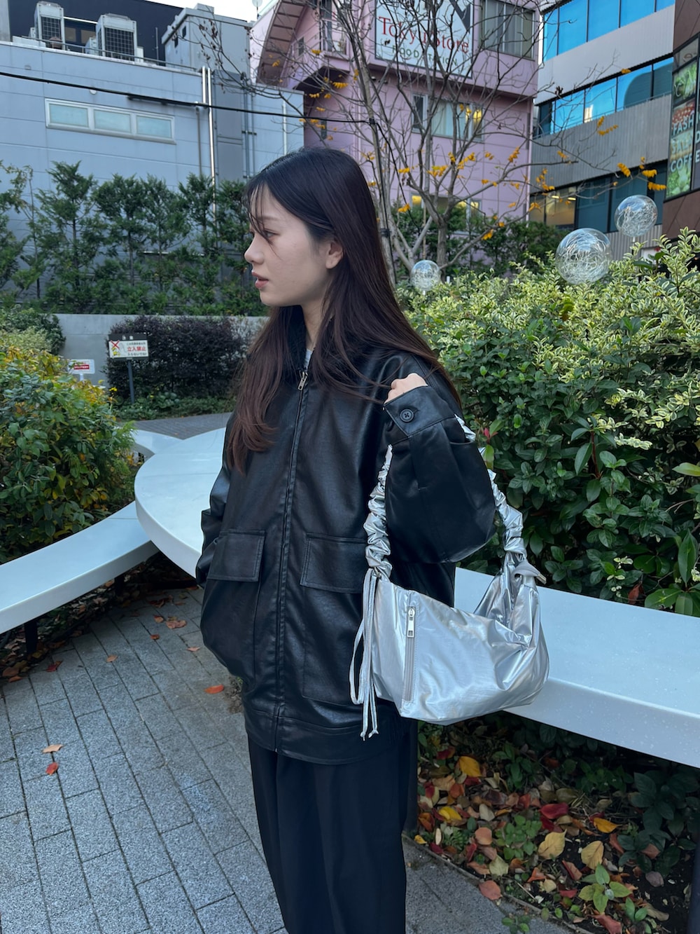 シルバー系のショルダーバッグ、ブラック系のブルゾン、ブラック系のカーゴパンツを着用したレディースの冬コーディネートの4枚目の写真