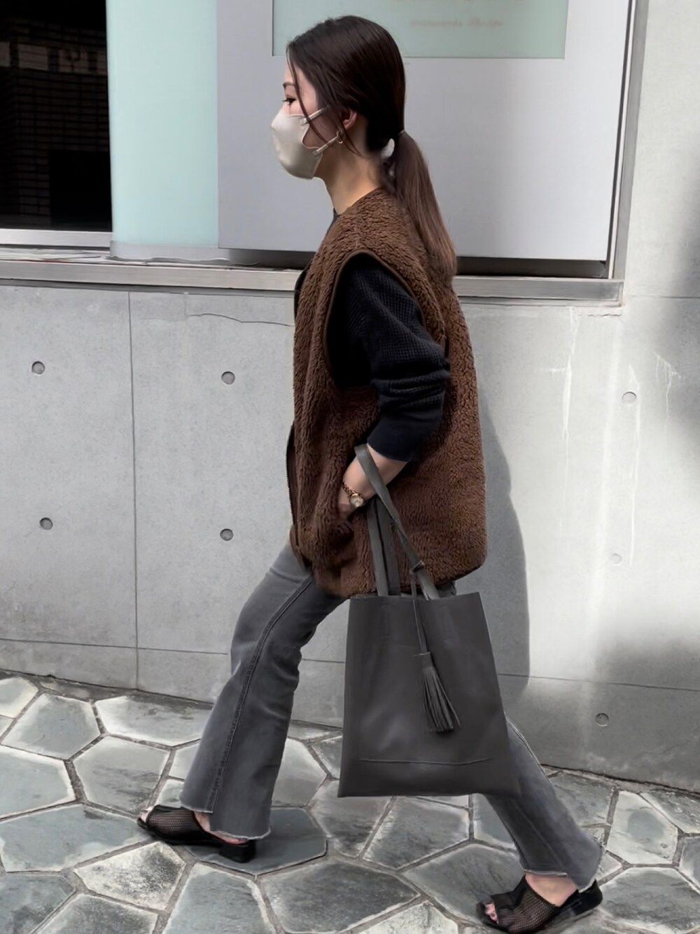 グレー系のトートバッグ、ブラック系のTシャツ/カットソー、ブラック系のデニムパンツを着用したレディースの秋コーディネートの2枚目の写真