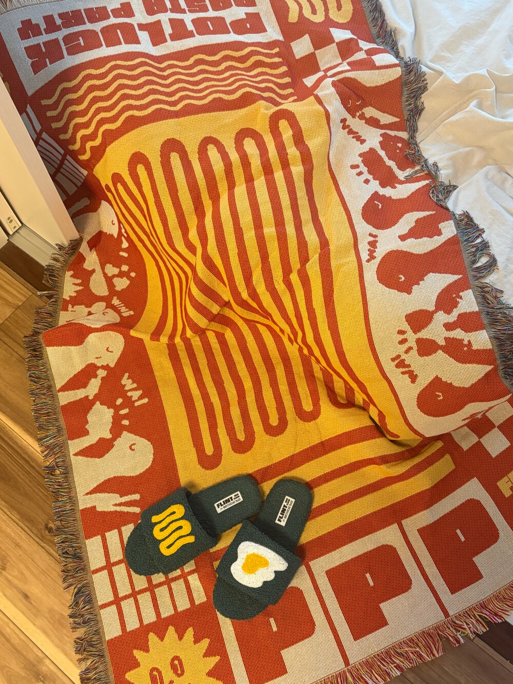 グリーン系のルームシューズ/スリッパ、オレンジ系のブランケットを着用したレディースの春コーディネートの2枚目の写真