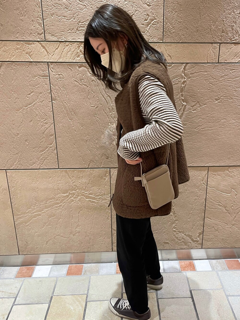 グレー系のスニーカー、ブラック系のその他パンツ、ベージュ系のショルダーバッグを着用したレディースの冬コーディネートの2枚目の写真