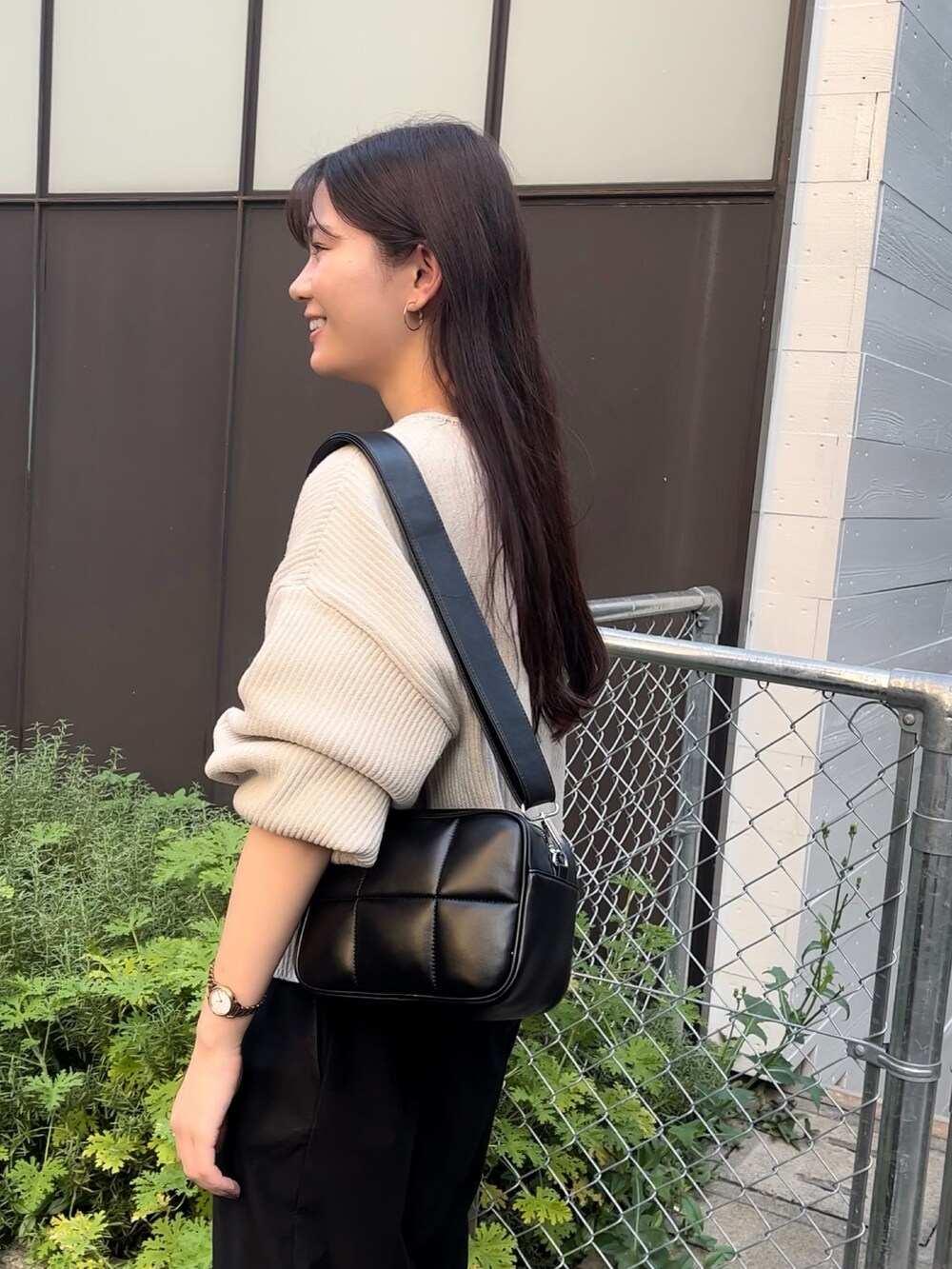 ブラック系のショルダーバッグ、ホワイト系のニット/セーター、ブラック系のカーゴパンツを着用したレディースの秋コーディネートの3枚目の写真
