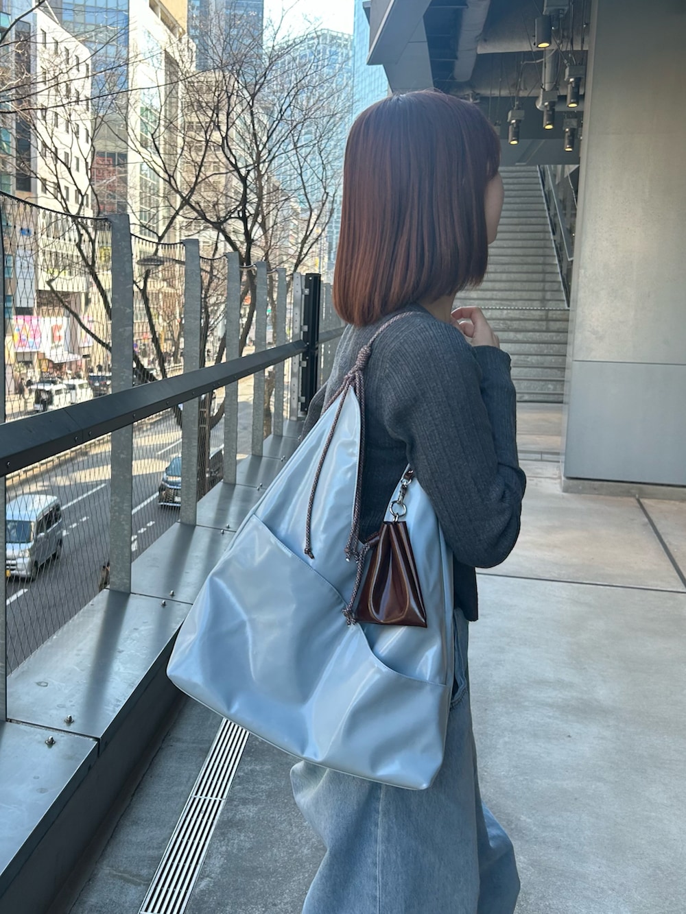 ブルー系のトートバッグを着用したレディースの春コーディネートの2枚目の写真