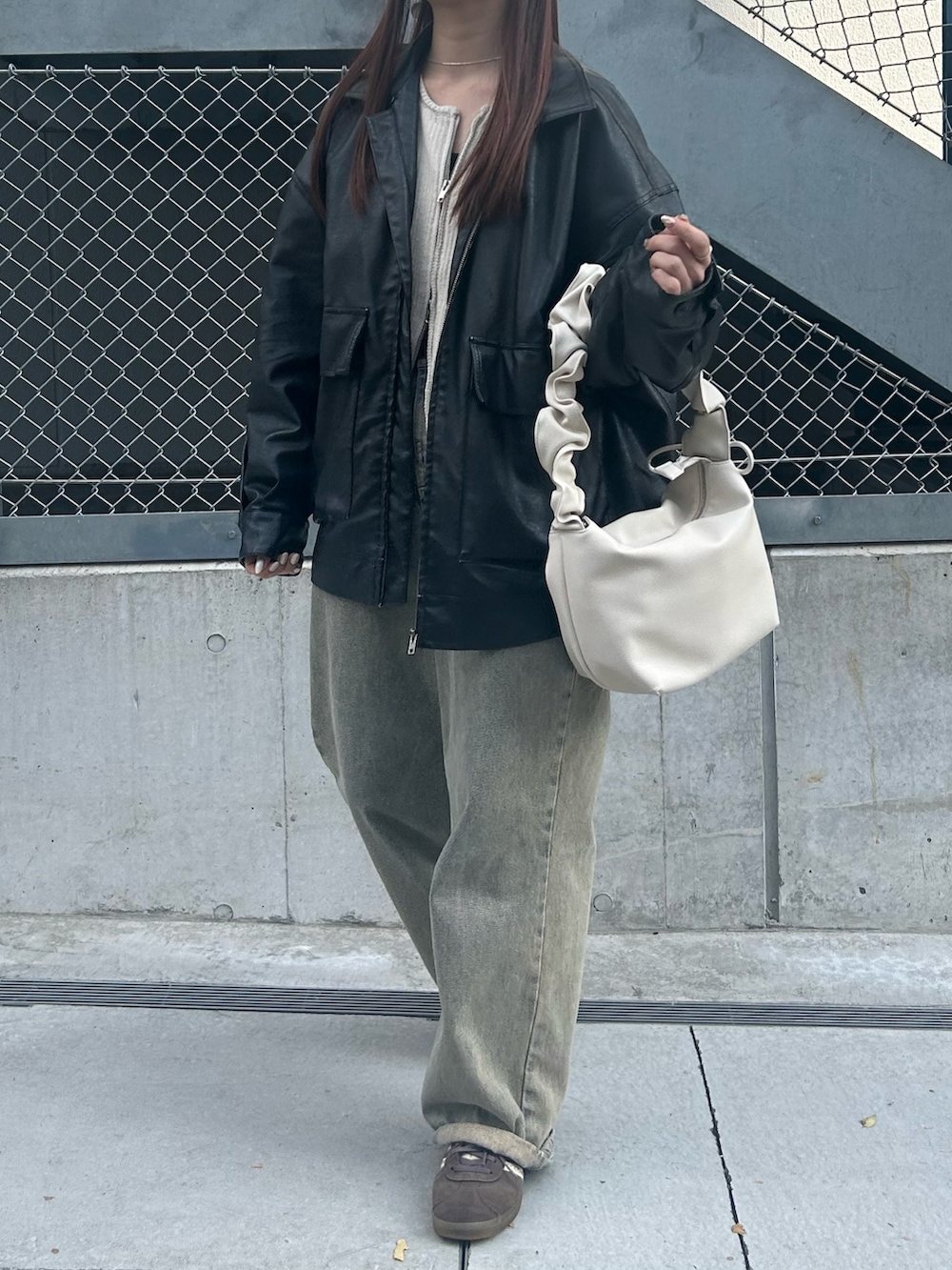 ホワイト系のトートバッグ、ブラック系のブルゾン、ホワイト系のニット/セーターを着用したレディースの冬コーディネートの2枚目の写真