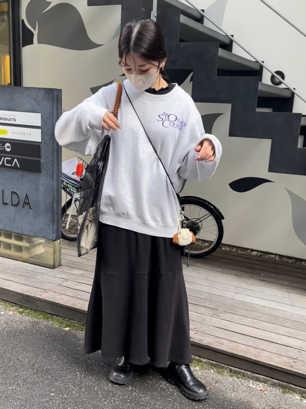 ブラック系のトートバッグ、グレー系のスウェット、ブラック系のTシャツ/カットソーを着用したレディースの冬コーディネートの3枚目の写真