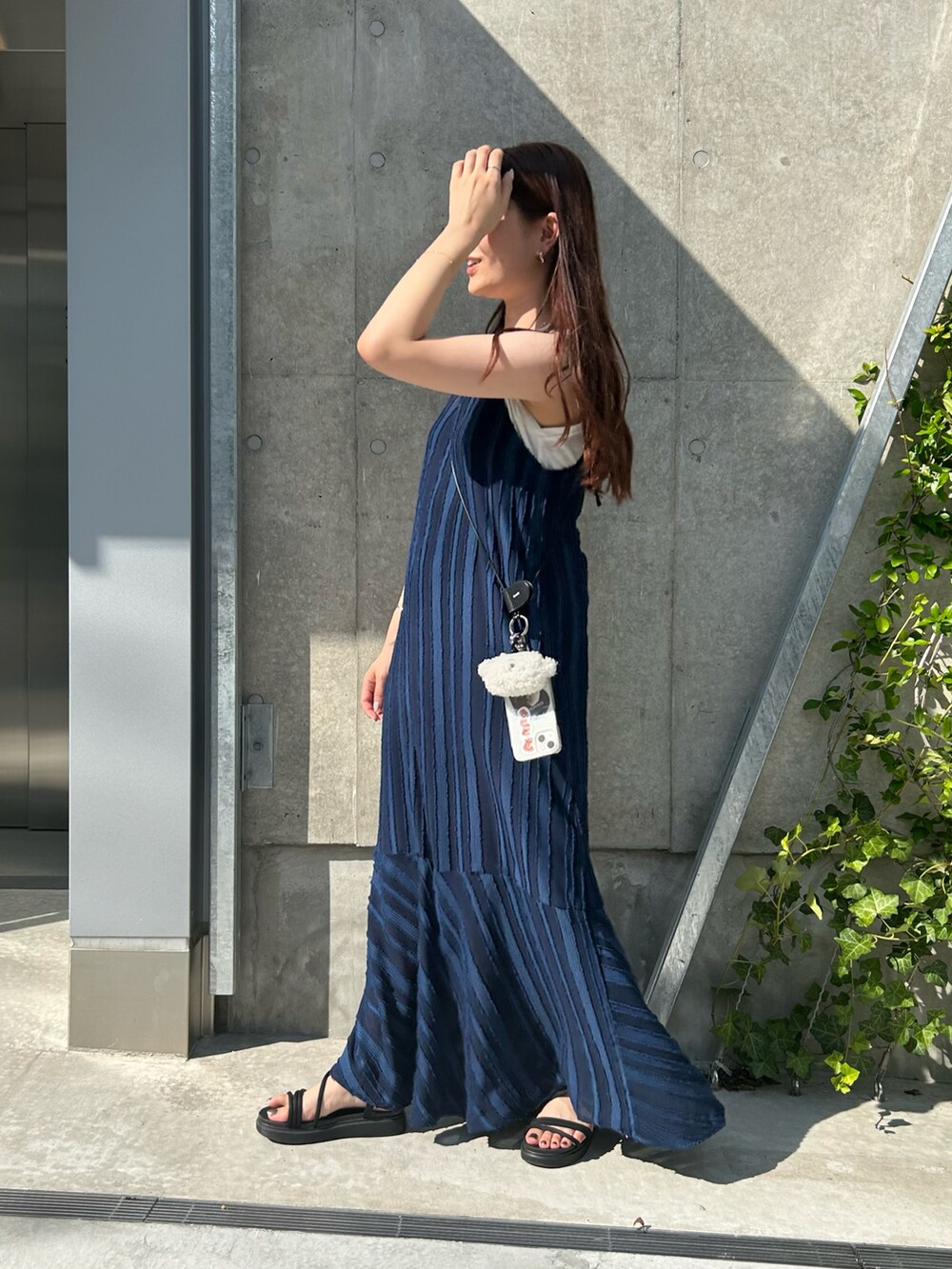 ブルー系のワンピース、ブラック系のスマホグッズ、ホワイト系のスマホグッズを着用したレディースの夏コーディネートの3枚目の写真