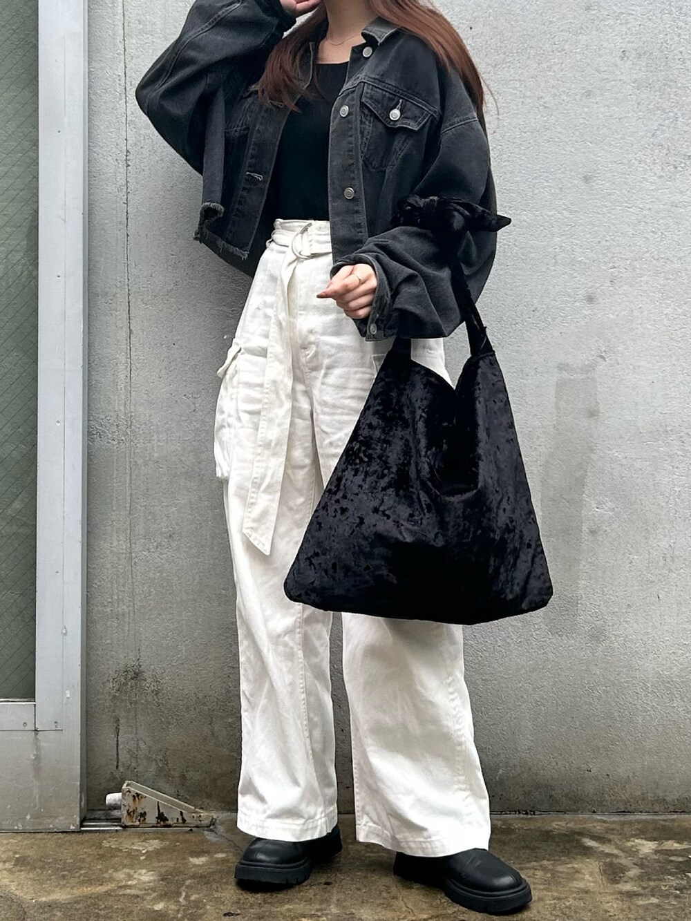 ブラック系のトートバッグ、ブラック系のデニムジャケット、ホワイト系のデニムパンツを着用したレディースの秋コーディネートの2枚目の写真