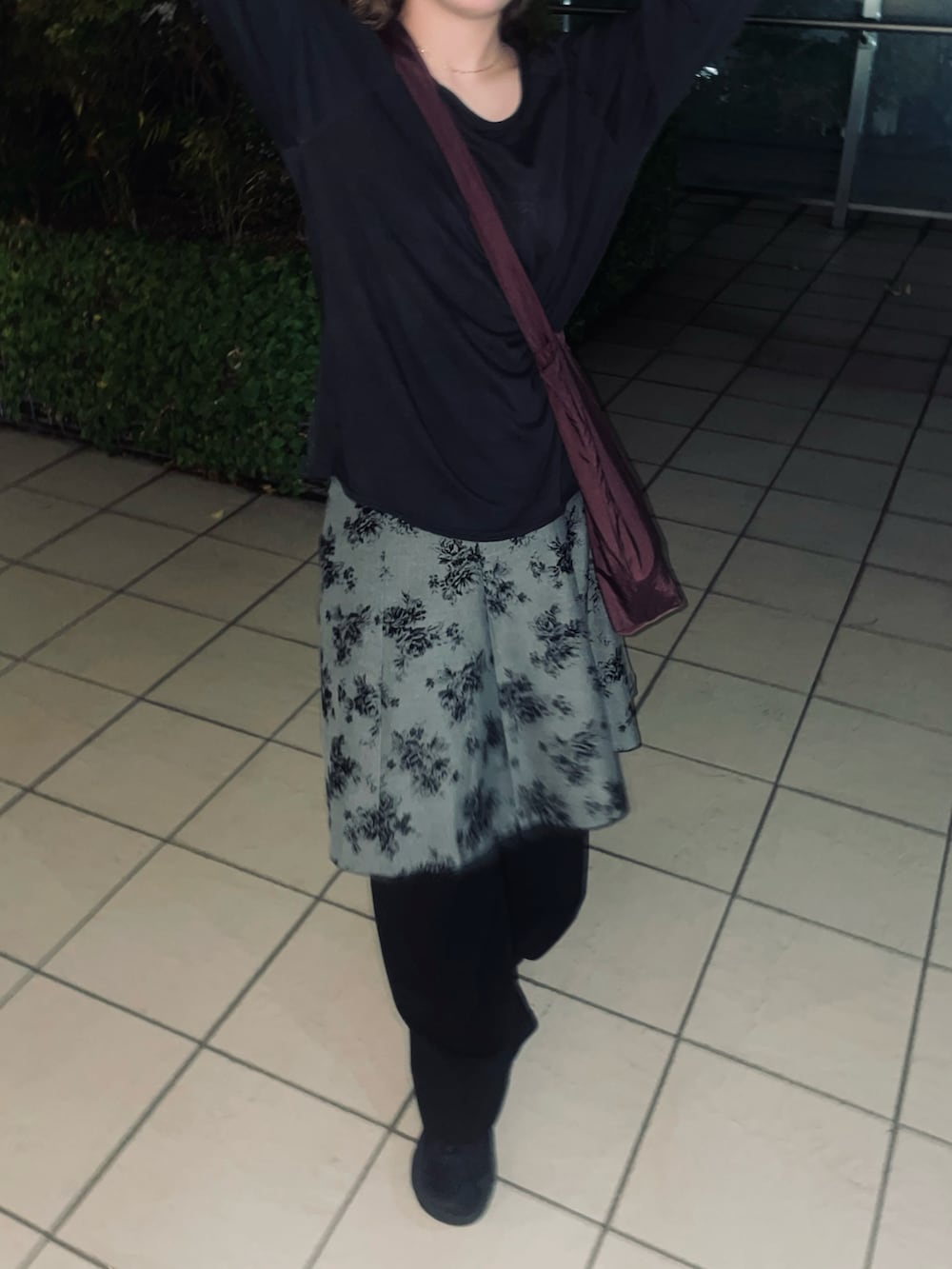 ブラック系のトップス、グレー系のスカート、ブラック系のシューズを着用したレディースの春コーディネートの2枚目の写真