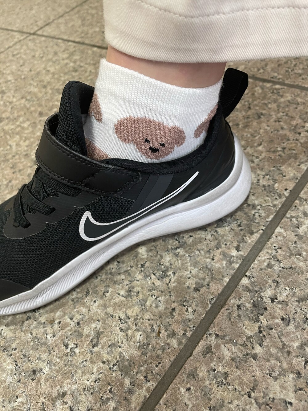 ブラック系のスニーカー、ホワイト系のスラックス、ホワイト系のTシャツ/カットソーを着用したキッズの春コーディネートの2枚目の写真