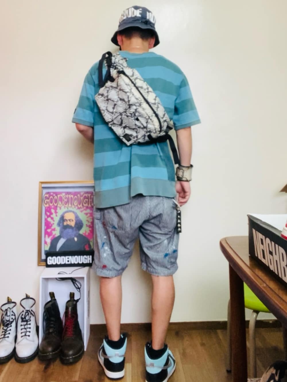 ブルー系のスウェット、ホワイト系のボディバッグ/ウエストポーチ、グレー系のデニムパンツを着用したメンズの夏コーディネートの2枚目の写真