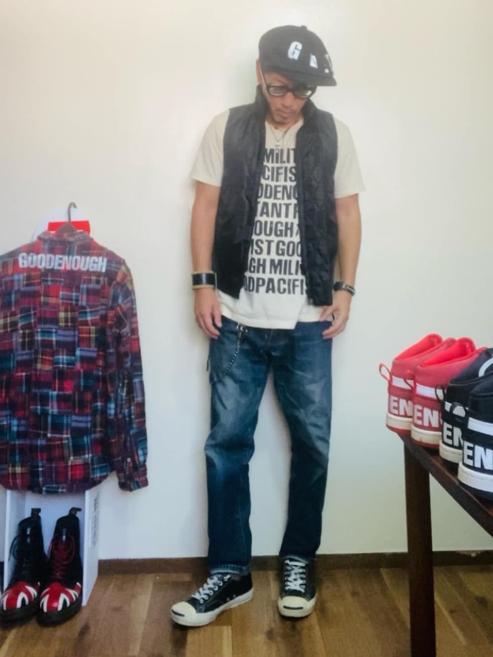 ベージュ系のTシャツ/カットソー、ブラック系のベスト、ブルー系のデニムパンツを着用したメンズの秋コーディネートの4枚目の写真