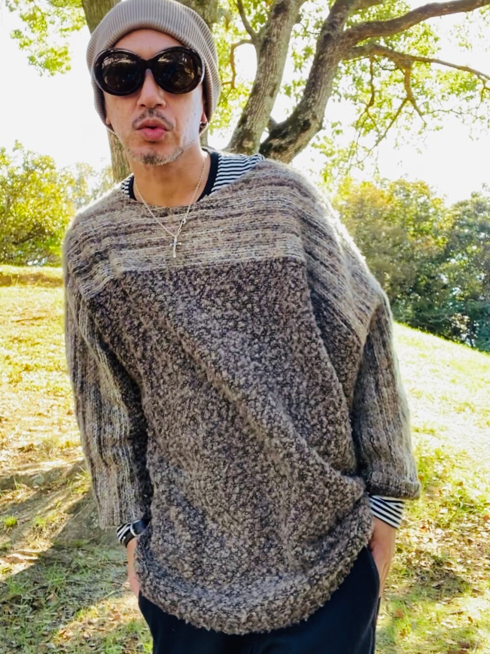 ブラウン系のニット/セーター、ブラック系のトップス、ブルー系のその他パンツを着用したメンズの秋コーディネートの4枚目の写真