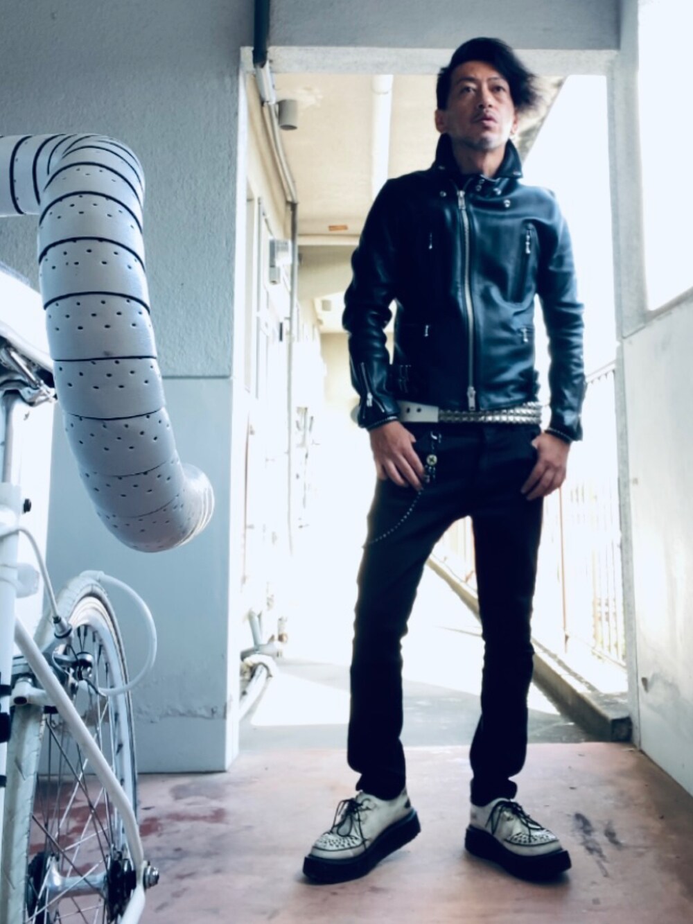 ブラック系のライダースジャケット、ホワイト系のTシャツ/カットソー、ブラック系のパンツを着用したメンズの秋コーディネートの4枚目の写真