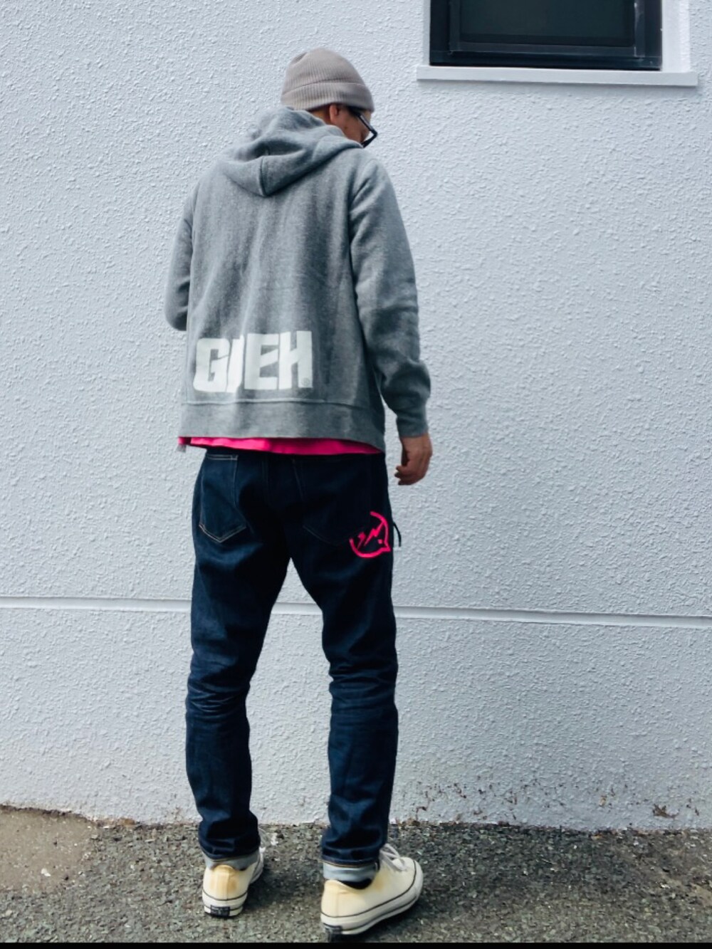 グレー系のパーカー、ピンク系のTシャツ/カットソー、ブルー系のデニムパンツを着用したメンズの春コーディネートの5枚目の写真