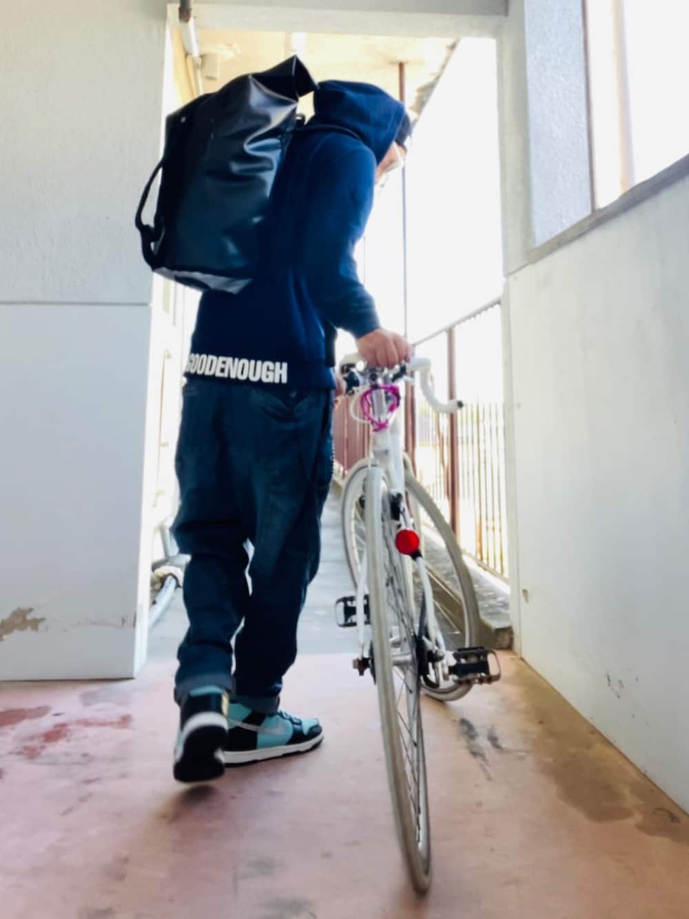 ブルー系のパーカー、ブラック系のバックパック/リュック、ブルー系のデニムパンツを着用したメンズの秋コーディネートの3枚目の写真