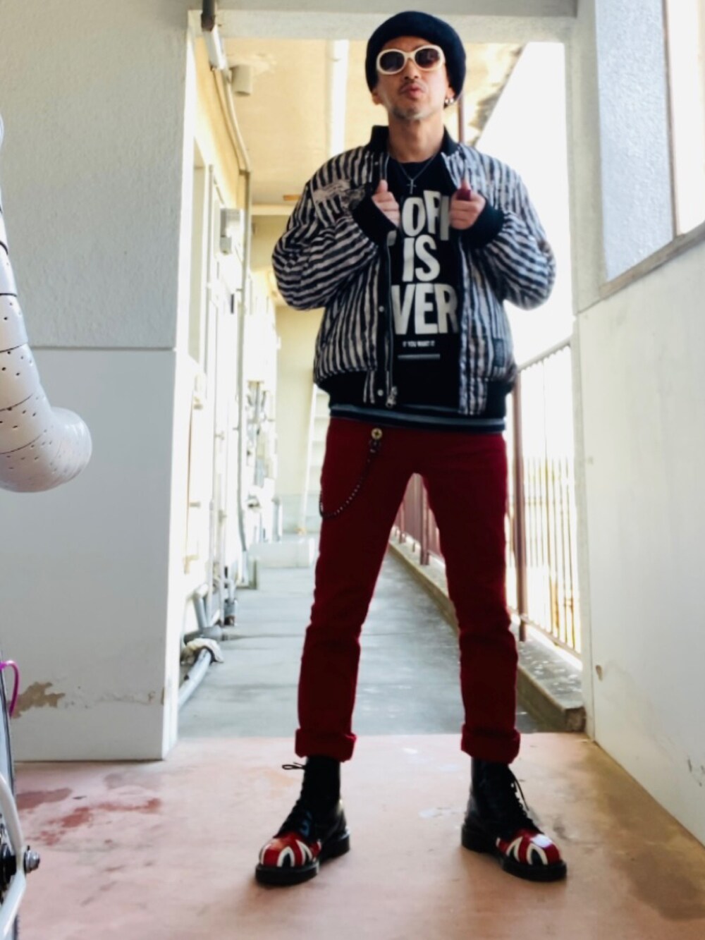 ブラック系のMA-1、ブラック系のタンクトップ、レッド系のデニムパンツを着用したメンズの秋コーディネートの4枚目の写真