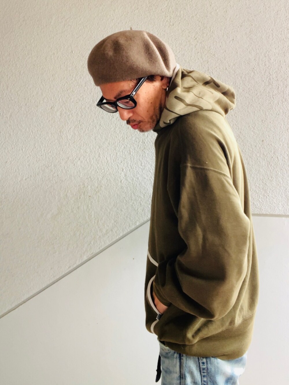 グリーン系のパーカー、ベージュ系のブーツ、ブルー系のその他パンツを着用したメンズの秋コーディネートの2枚目の写真