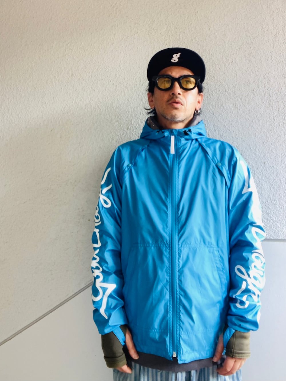 ブルー系のナイロンジャケット、ブルー系のデニムパンツ、グリーン系のスニーカーを着用したメンズの冬コーディネートの3枚目の写真