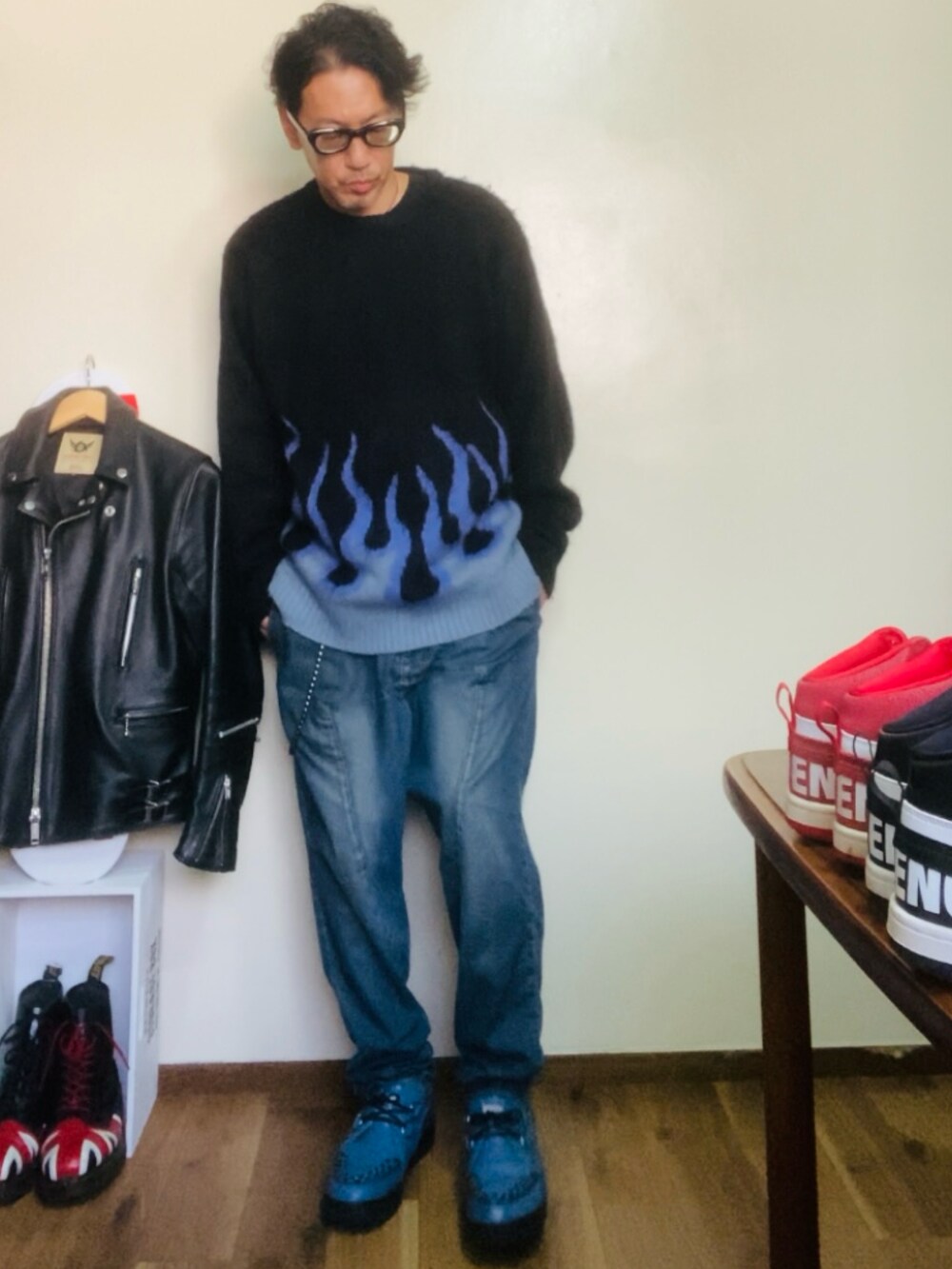 ブラック系のニット/セーター、ブルー系のデニムパンツ、ブルー系のブーツを着用したメンズの秋コーディネートの2枚目の写真