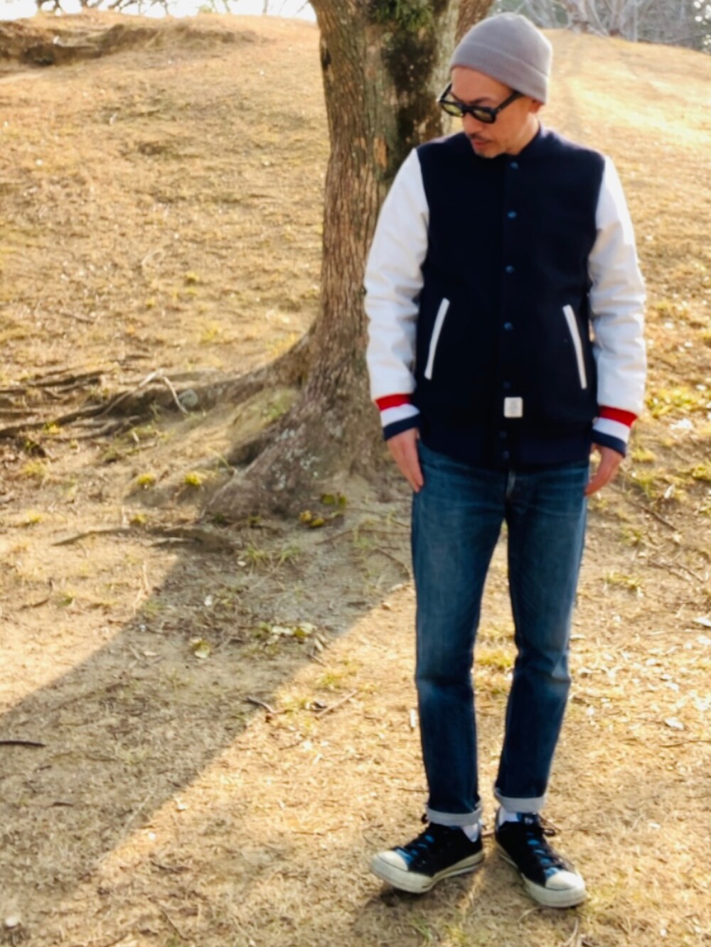 ブラック系のスタジャン、ブルー系のデニムパンツ、ブラック系のスニーカーを着用したメンズの冬コーディネートの3枚目の写真