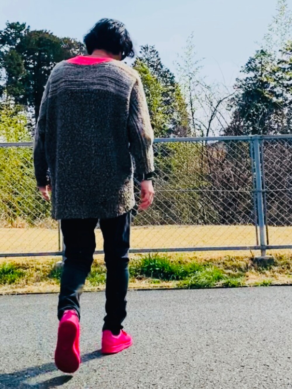 ブラウン系のニット/セーター、ピンク系のTシャツ/カットソー、ブラック系のデニムパンツを着用したメンズの春コーディネートの3枚目の写真