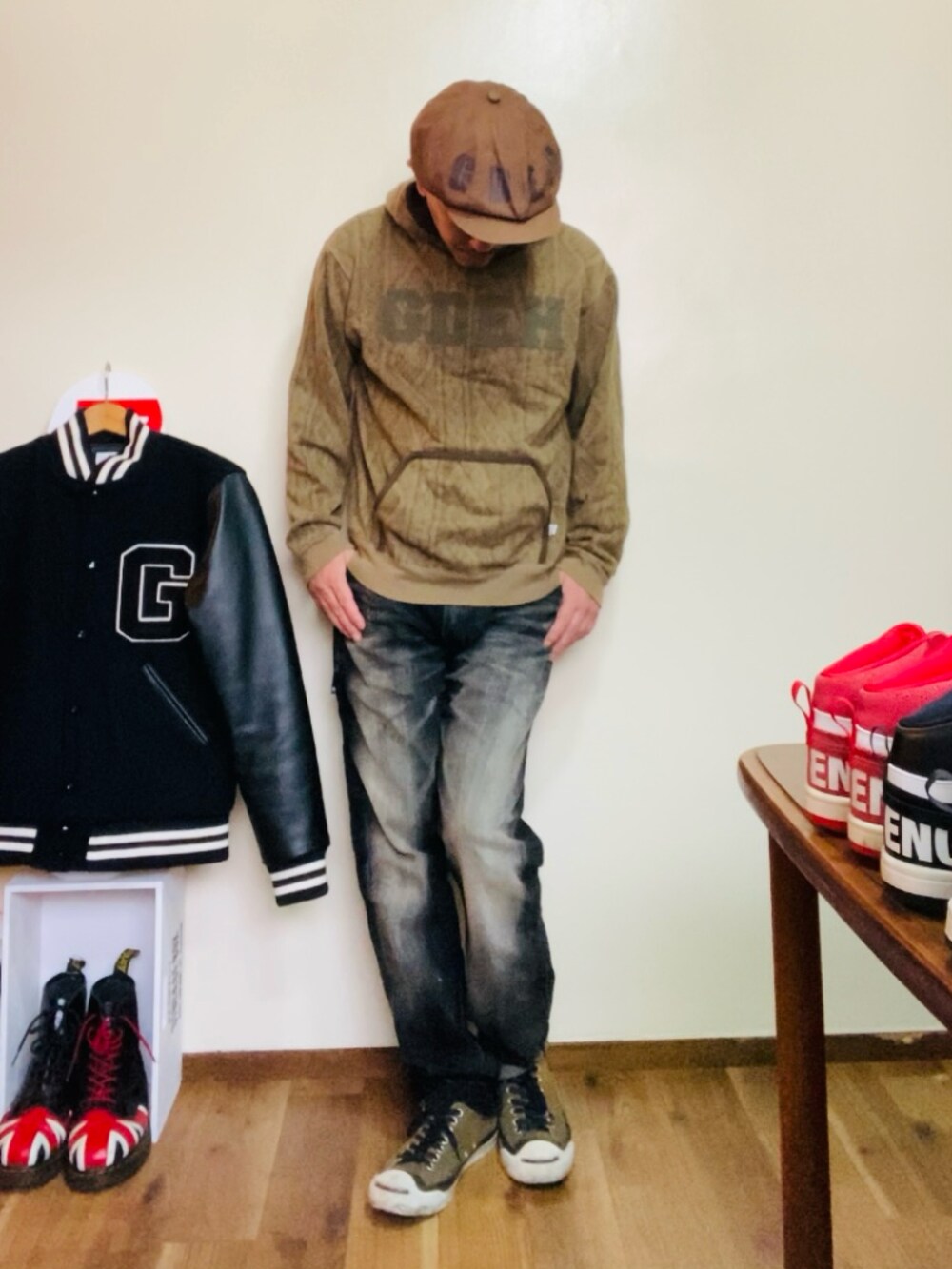 ブラウン系のパーカー、ブラック系のデニムパンツ、グリーン系のスニーカーを着用したメンズの秋コーディネートの3枚目の写真