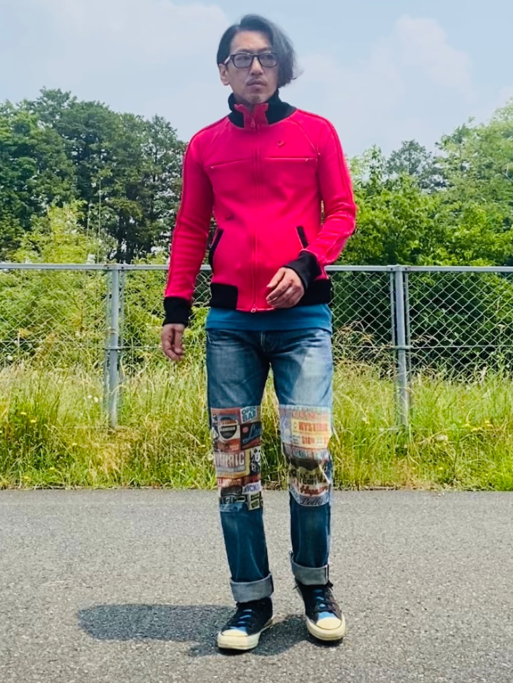 ピンク系のジャージ、ブルー系のデニムパンツ、ブラック系のスニーカーを着用したメンズの春コーディネートの2枚目の写真