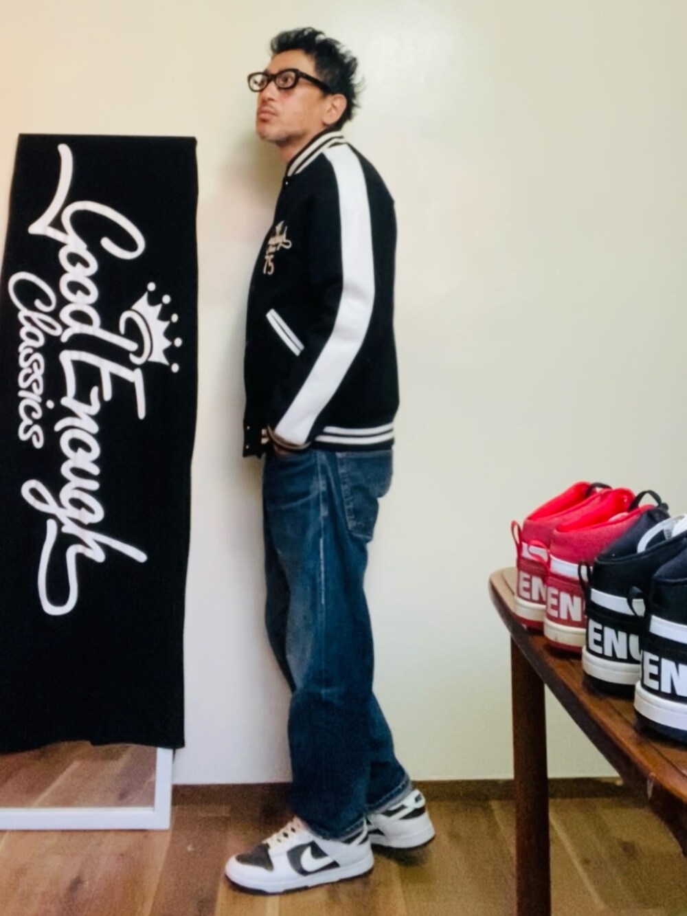 ブラック系のスタジャン、ブルー系のデニムパンツ、ホワイト系のスニーカーを着用したメンズの冬コーディネートの2枚目の写真
