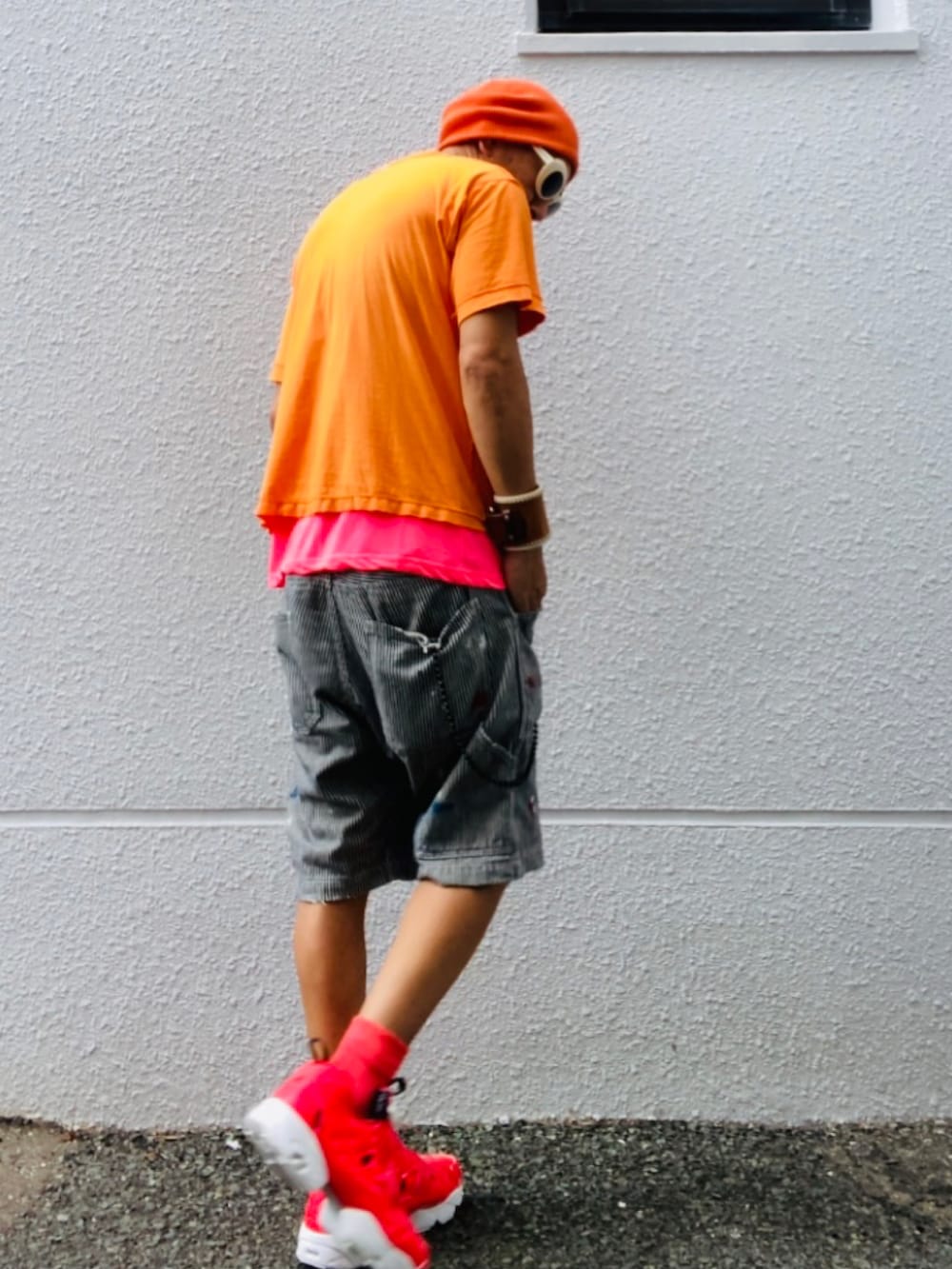 オレンジ系のTシャツ/カットソー、ピンク系のTシャツ/カットソー、グレー系のデニムパンツを着用したメンズの秋コーディネートの5枚目の写真