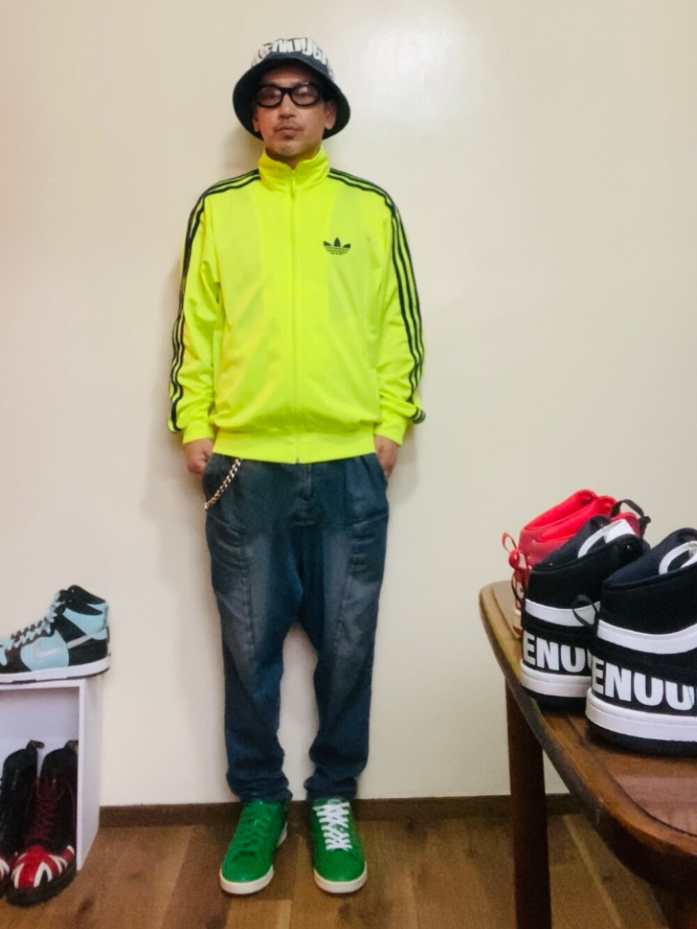 イエロー系のジャージ、ブルー系のデニムパンツ、グリーン系のスニーカーを着用したメンズの春コーディネートの2枚目の写真
