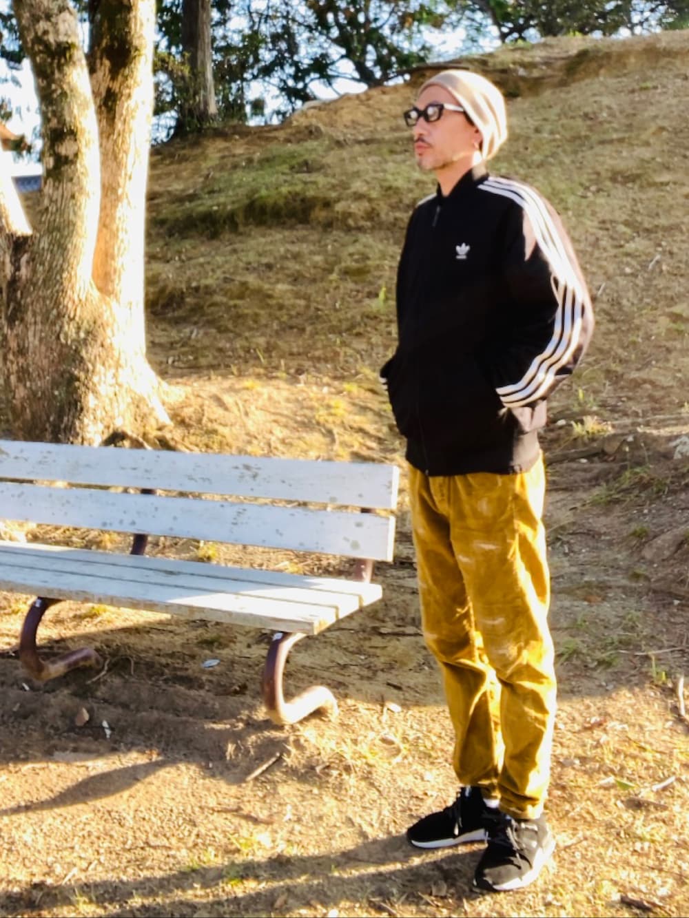 ブラック系のジャージ、イエロー系のその他パンツ、ブラック系のスニーカーを着用したメンズの冬コーディネートの2枚目の写真