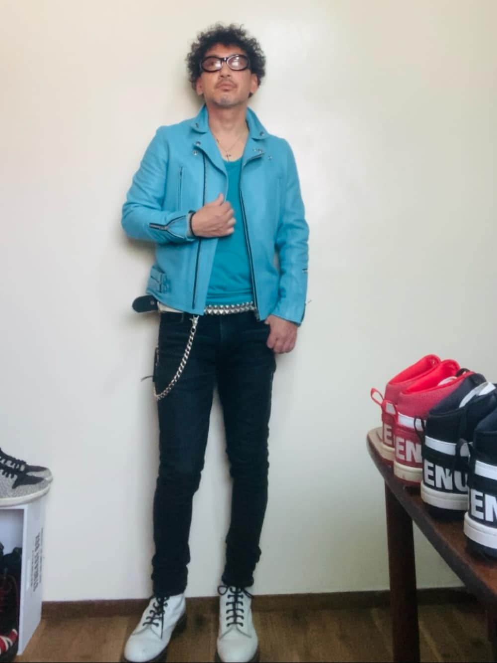 ブルー系のライダースジャケット、ブラック系のデニムパンツ、ホワイト系のブーツを着用したメンズの秋コーディネートの5枚目の写真