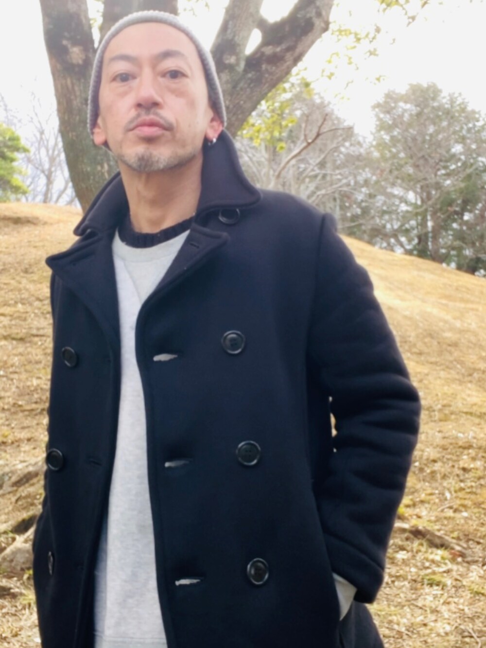 ブルー系のピーコート、グレー系のスウェット、ホワイト系のデニムパンツを着用したメンズの冬コーディネートの4枚目の写真