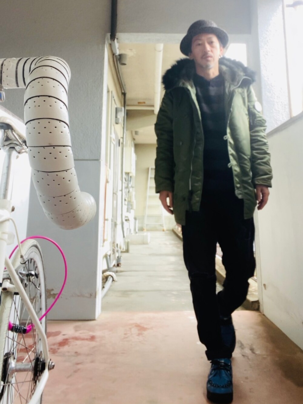 グリーン系のミリタリージャケット、グレー系のニット/セーター、ブラック系のその他パンツを着用したメンズの冬コーディネートの4枚目の写真