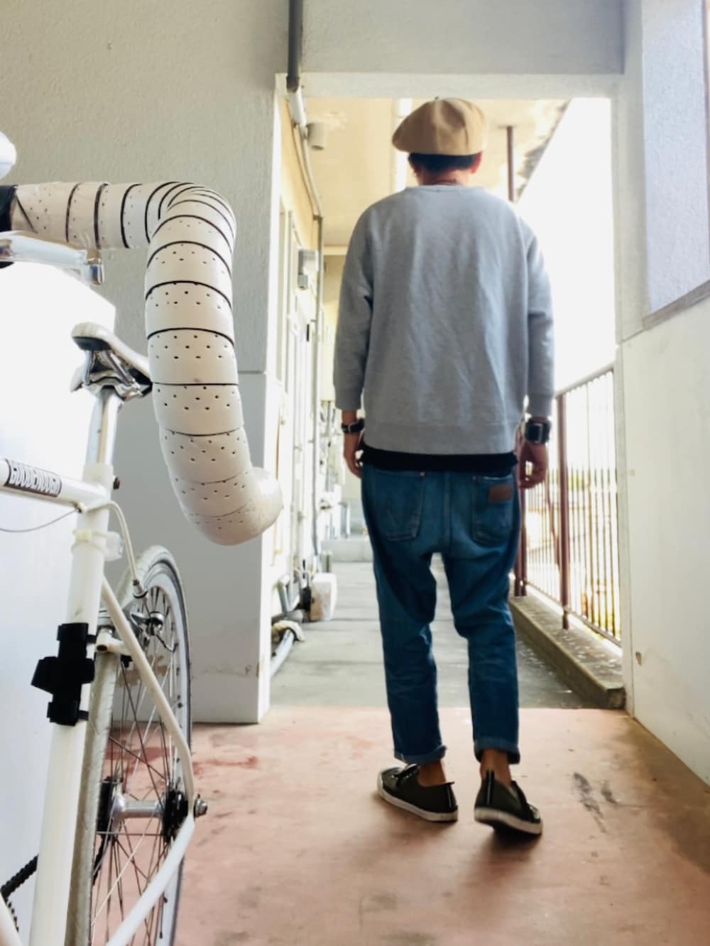 グレー系のスウェット、ブルー系のデニムパンツ、グリーン系のスニーカーを着用したメンズの秋コーディネートの3枚目の写真