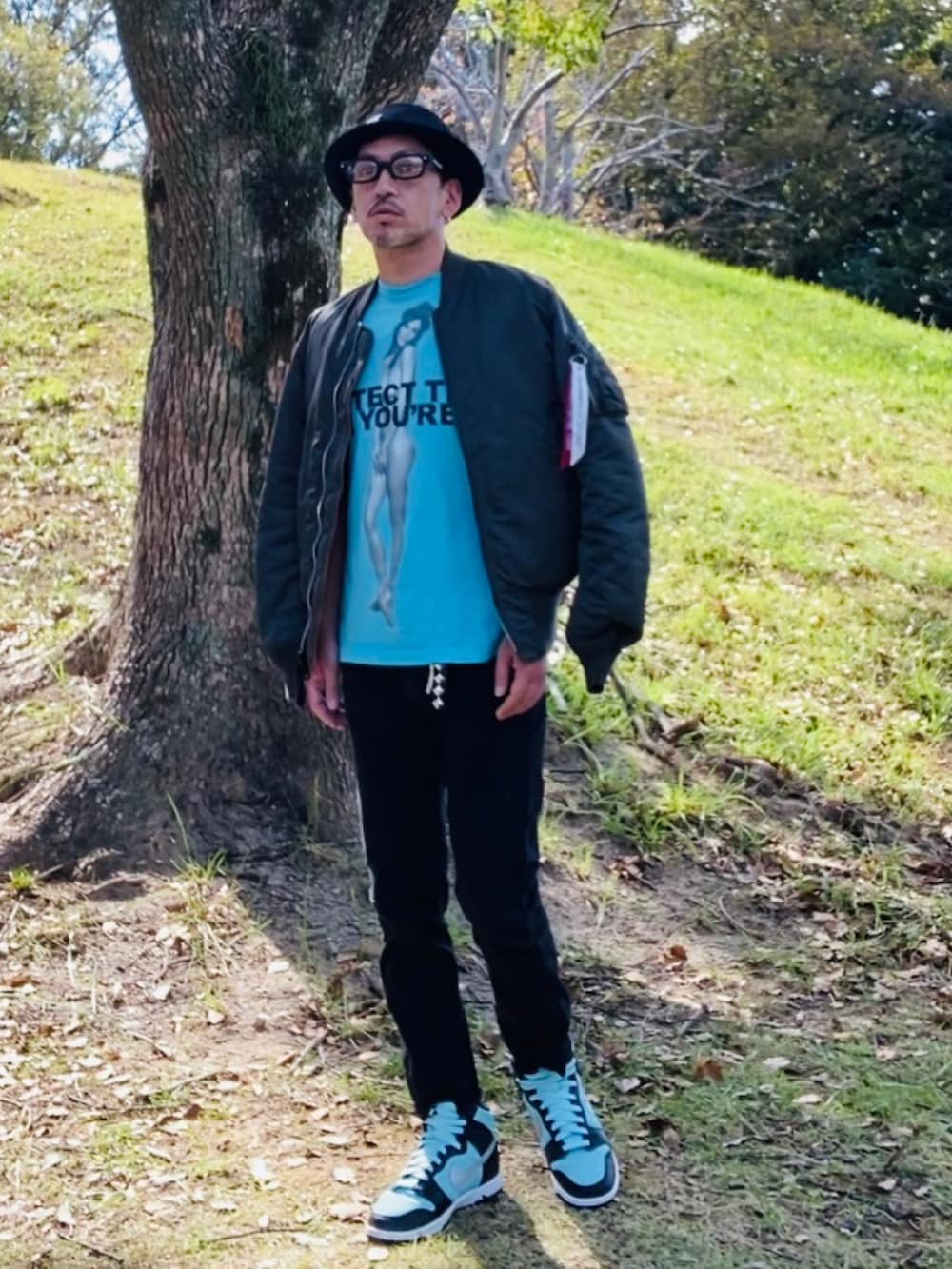 グレー系のMA-1、ブルー系のTシャツ/カットソー、ブラック系のデニムパンツを着用したメンズの秋コーディネートの5枚目の写真