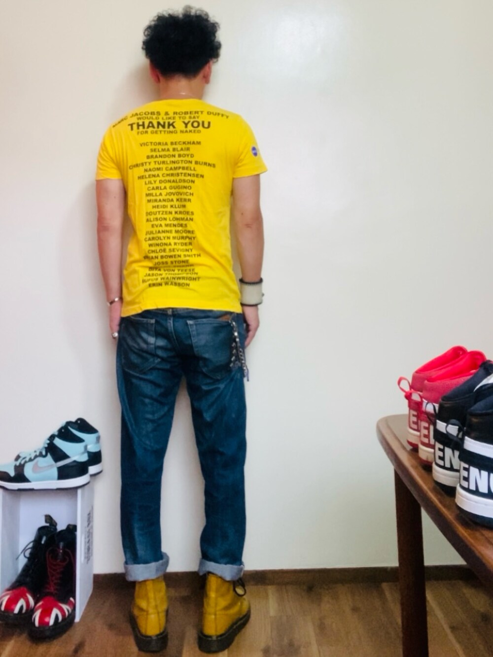 イエロー系のブーツ、イエロー系のTシャツ/カットソー、ブルー系のデニムパンツを着用したメンズの夏コーディネートの2枚目の写真