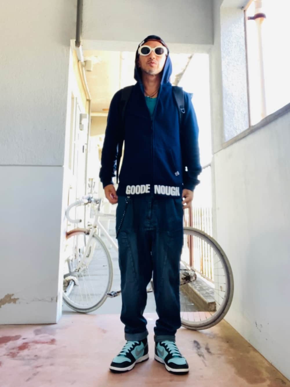 ブルー系のパーカー、ブラック系のバックパック/リュック、ブルー系のデニムパンツを着用したメンズの秋コーディネートの5枚目の写真