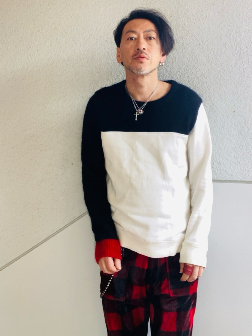 ブラック系のニット/セーター、レッド系のその他パンツ、レッド系のブーツを着用したメンズの春コーディネートの5枚目の写真