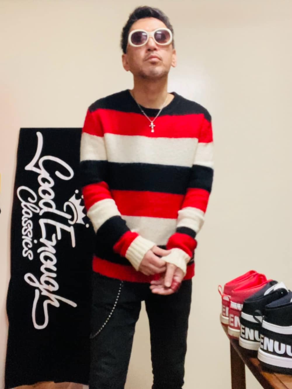 レッド系のニット/セーター、ブラック系のパンツ、ホワイト系のその他シューズを着用したメンズの冬コーディネートの4枚目の写真