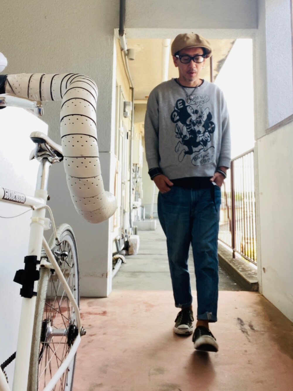 グレー系のスウェット、ブルー系のデニムパンツ、グリーン系のスニーカーを着用したメンズの秋コーディネートの4枚目の写真
