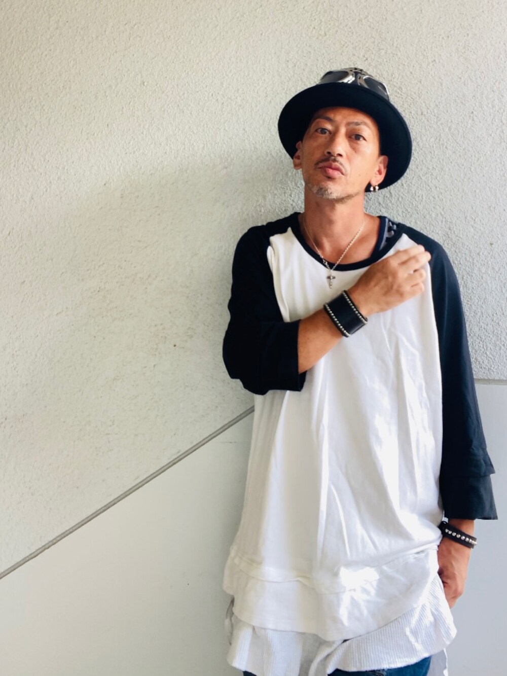 ブルー系のデニムパンツ、ブラック系のスニーカー、ブラック系のショルダーバッグを着用したメンズの夏コーディネートの4枚目の写真