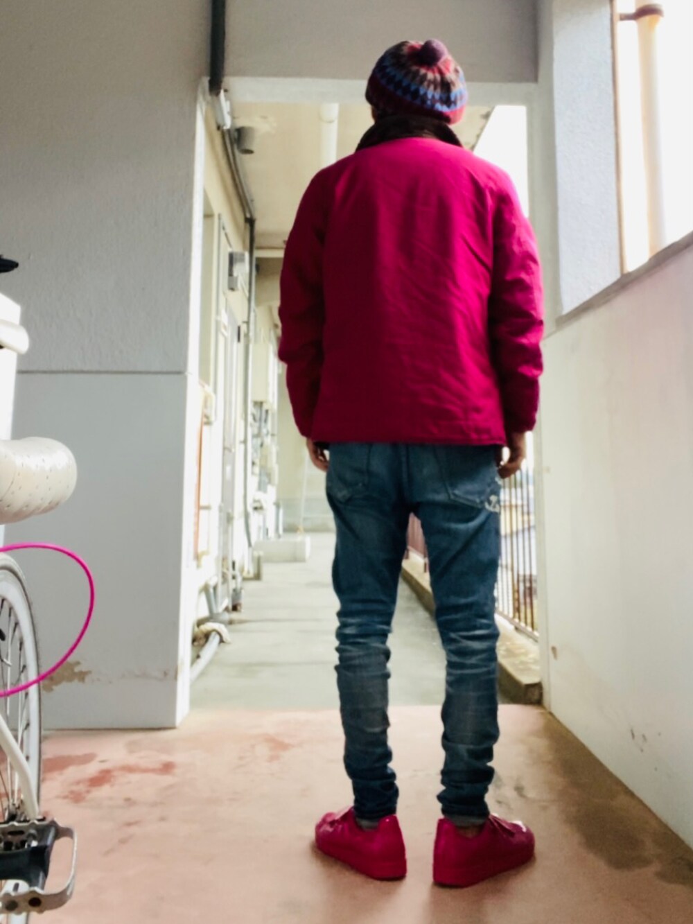 ピンク系のニット/セーター、ピンク系のミリタリージャケット、ブルー系のデニムパンツを着用したメンズの冬コーディネートの3枚目の写真