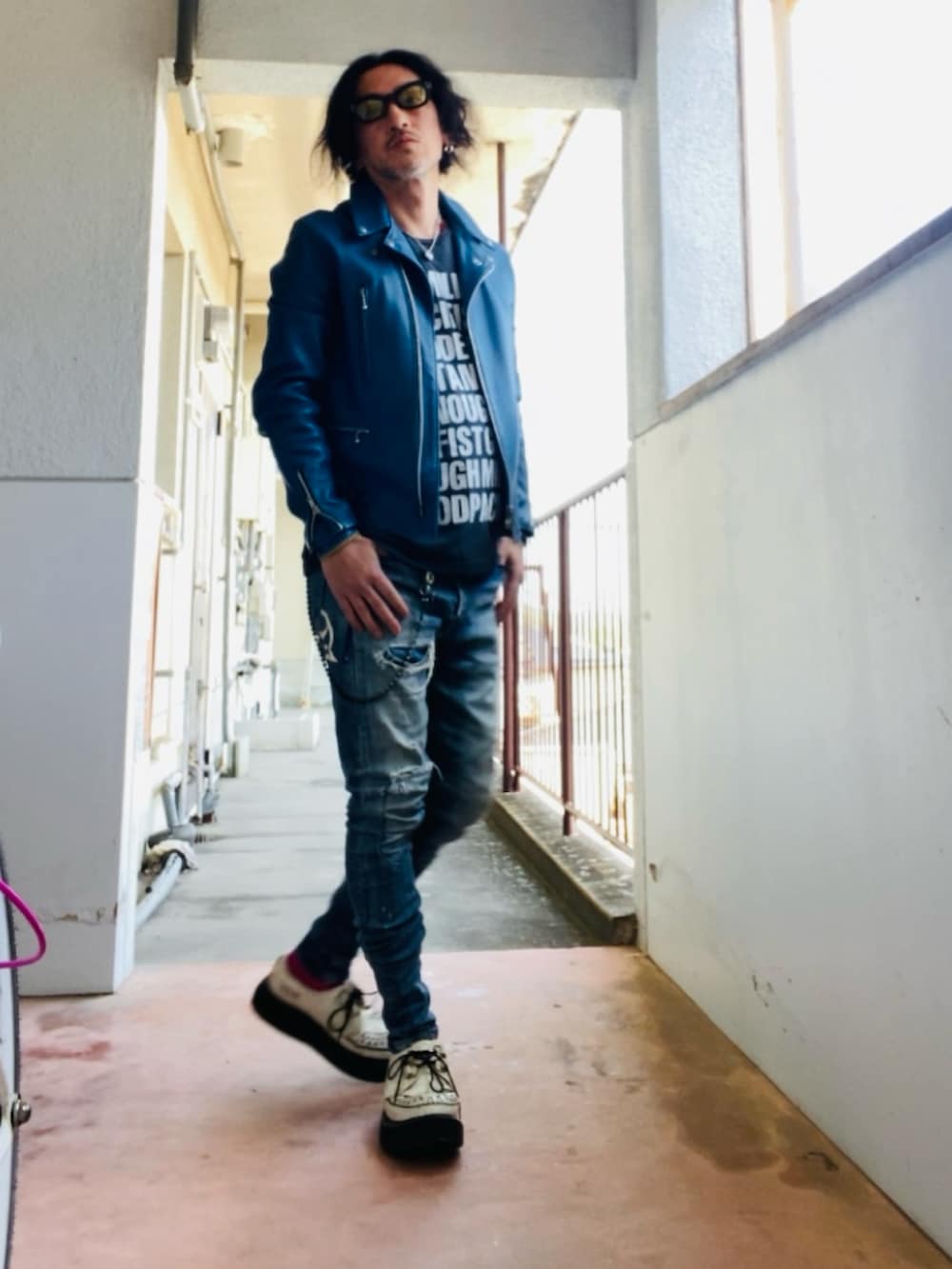 ブルー系のライダースジャケット、ブラック系のTシャツ/カットソー、ブルー系のデニムパンツを着用したメンズの春コーディネートの4枚目の写真