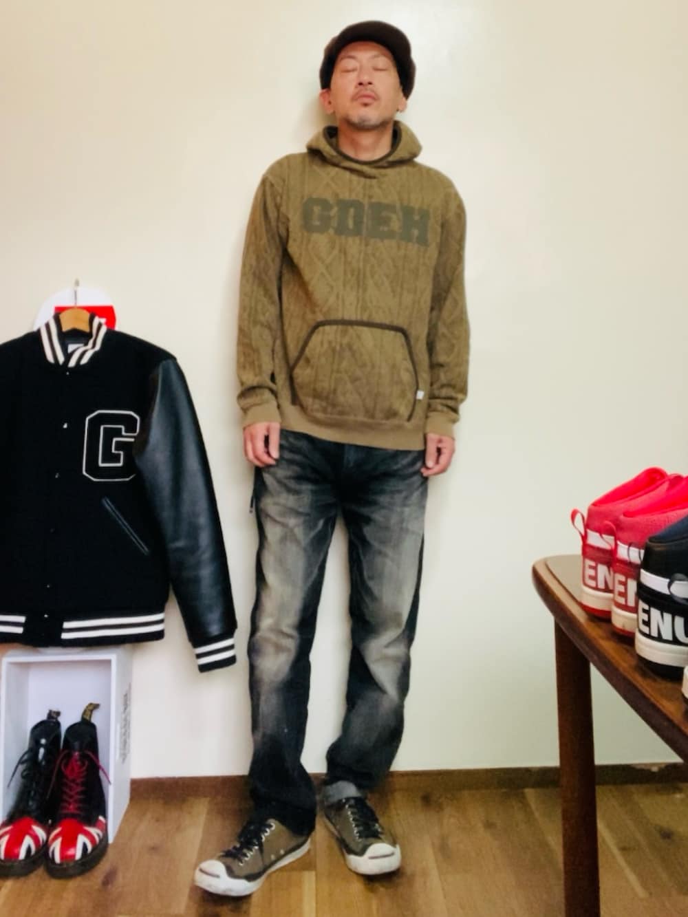 ブラウン系のパーカー、ブラック系のデニムパンツ、グリーン系のスニーカーを着用したメンズの秋コーディネートの2枚目の写真