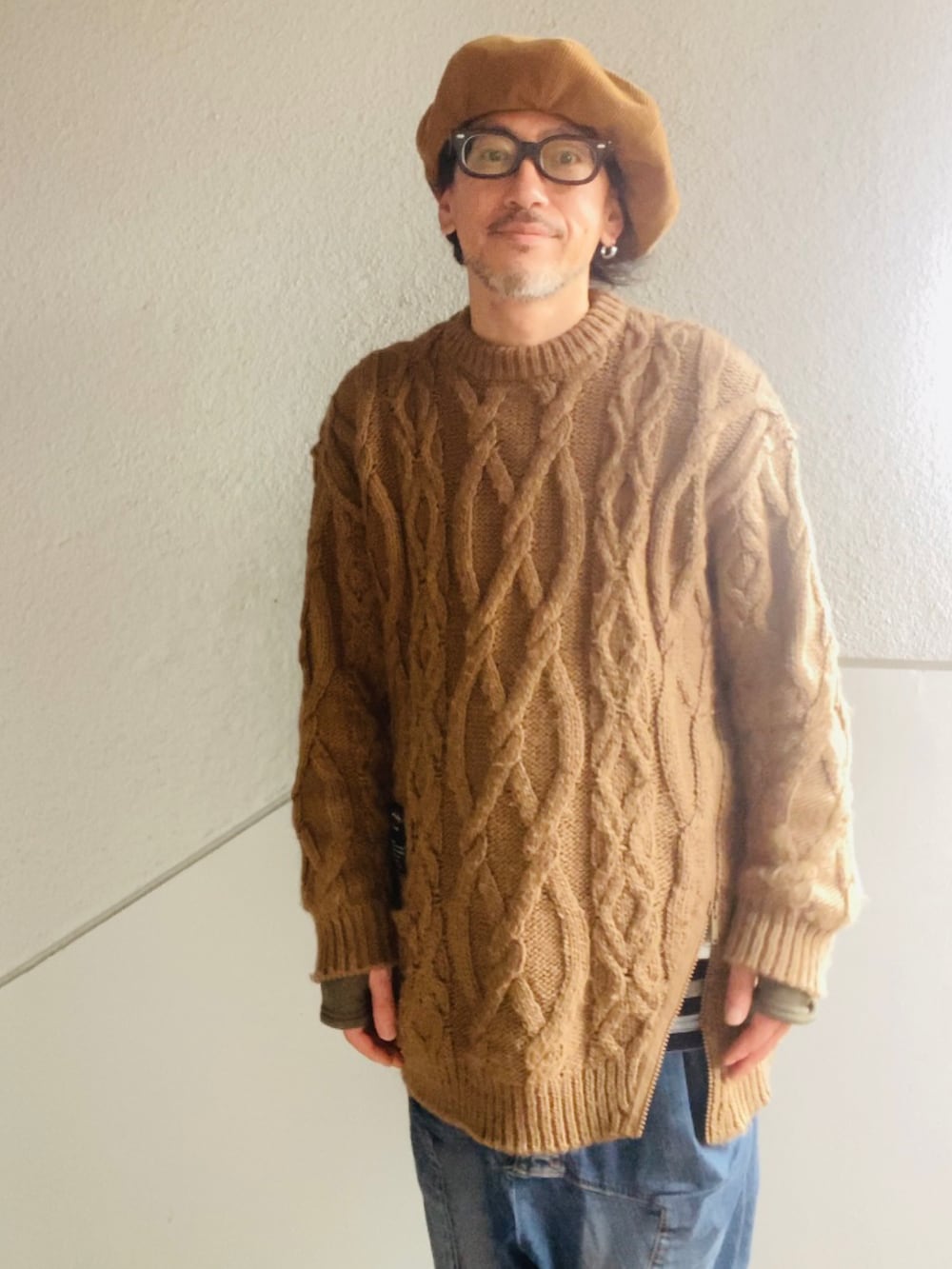 ブラウン系のニット/セーター、ブルー系のデニムパンツ、ベージュ系のブーツを着用したメンズの冬コーディネートの5枚目の写真